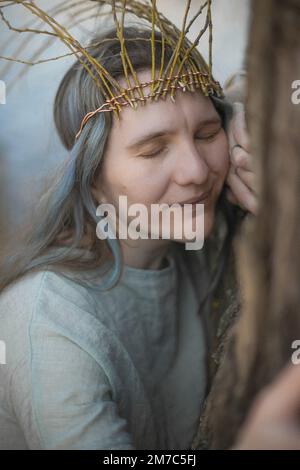 Gros plan celtic style femme embrassant l'arbre avec un portrait de sourire soulagé Banque D'Images