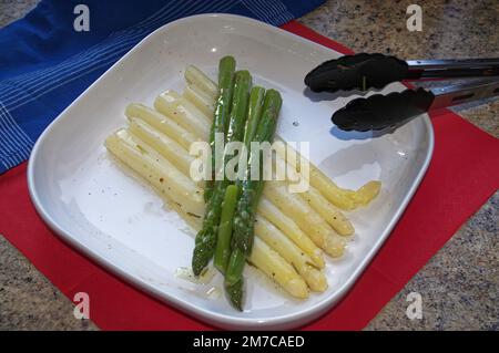 Asperges blanches et vertes sur Une assiette avec vinaigrette et pinces de service, asperges officinalis Banque D'Images