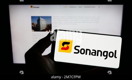 Personne tenant un smartphone avec le logo de la compagnie pétrolière angolaise Group Sonangol sur l'écran devant le site Web. Mise au point sur l'affichage du téléphone. Banque D'Images