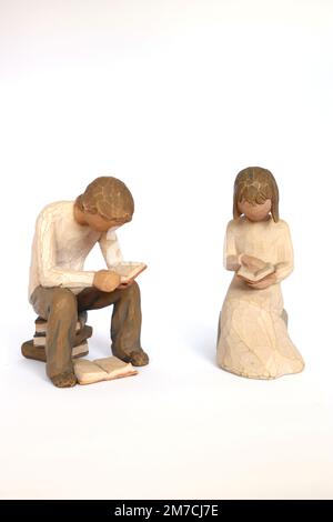 Un homme et une femme assis sur des livres lisant un livre. Les ornements sont issus de la collection populaire de saule par Demdaco par Susan Lordi pour les collectionneurs Banque D'Images