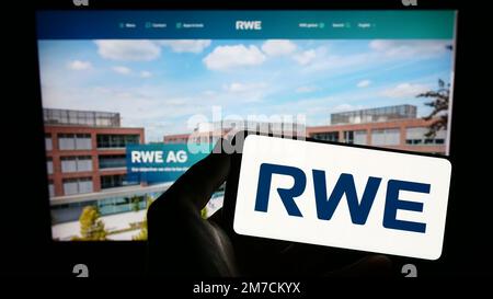 Personne tenant un smartphone avec le logo de la société allemande d'énergie RWE AG à l'écran devant le site Web. Mise au point sur l'affichage du téléphone. Banque D'Images