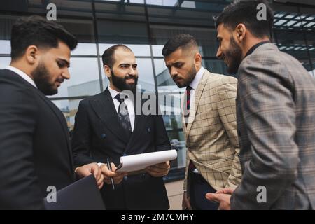 Réunions en extérieur pour les personnes en voyage d'affaires. Les hommes en veston discutent des moments de travail ensemble par remue-méninges. Travail d'équipe et partenariat dans les processus d'affaires Banque D'Images