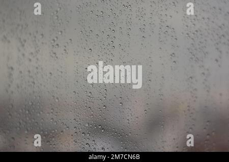 Vue à travers une fenêtre avec des gouttes de pluie sur elle à d'autres maisons le jour de la pluie, hiver à Antalya, Turquie Banque D'Images