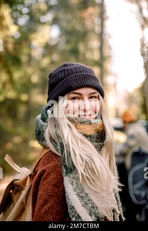 Portrait d'une femme blonde souriante portant un chapeau en tricot Banque D'Images