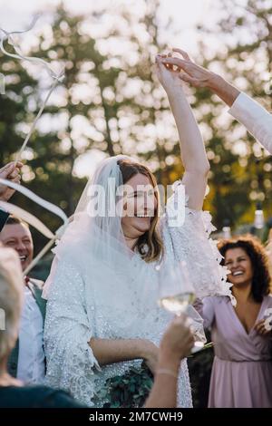 Un couple heureux et jeune dansant au milieu de la famille et des amis lors du mariage Banque D'Images