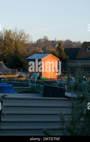 Un jardin se délasser sur un terrain gelé baigné dans la lumière du soleil tôt le matin. Banque D'Images