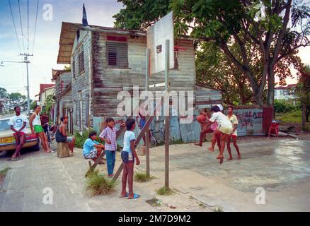 Surinam, la jeunesse est accrochée dans la rue à Paramaribo à côté d'une voiture garée qui a été importée de l'ancien dirigeant colonial des pays-Bas. Banque D'Images