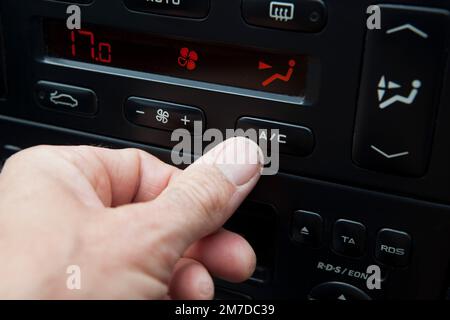 Le conducteur ou le passager d'une voiture allume la climatisation dans le véhicule pour maintenir l'habitacle aussi frais que possible pendant la chaleur des mois d'été de l'ion Royaume-Uni. Banque D'Images