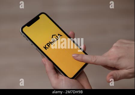 3 décembre 2022 Almaty Kazakhstan: Femme sans visage portant un smartphone avec logo de toit. Banque D'Images