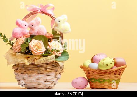 La composition de Pâques reste la vie. Paniers avec roses et œufs sur la table. Banque D'Images