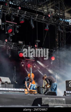 Scène rock avec des musiciens préparant leurs instruments et faisceaux de lumière à travers la fumée Banque D'Images