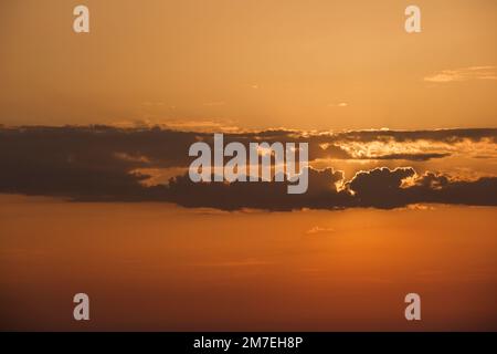 Des nuages et des conditions météorologiques spectaculaires à l'horizon au-dessus de la mer avec des reflets de la lumière du soleil sur la mer et des nuages roses profonds et colorés se reflétant dans l'eau de mer. Banque D'Images