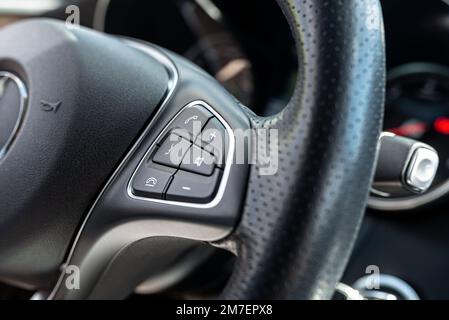 Volant multifonction en cuir dans une voiture de luxe, touches d'appel et de volume visibles sur le côté droit. Banque D'Images