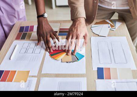 Gros plan de deux concepteurs qui choisissent des nuances de couleurs tout en travaillant sur un projet UX au bureau Banque D'Images