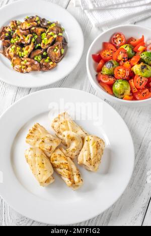 Portion de calamars frits avec champignons shiitake et salade de tomates Banque D'Images