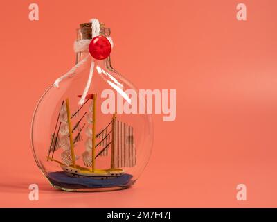 Expédier dans une bouteille sur fond rose. Gros plan. Banque D'Images