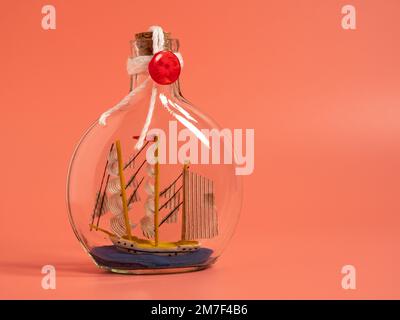 Expédier dans une bouteille sur fond rose. Gros plan. Banque D'Images