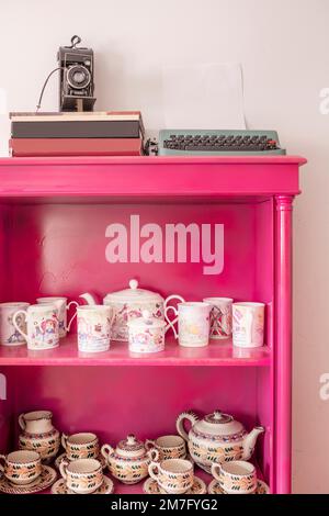 Buffets peints en rose avec ensemble à thé et articles décoratifs vintage Banque D'Images