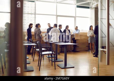 Les employés de bureau communiquent entre eux tout en ayant des conversations informelles pendant les pauses. Banque D'Images