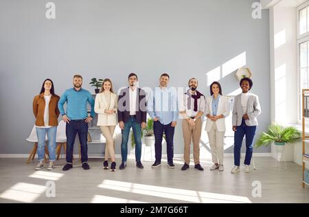 Portrait des employés d'une équipe d'affaires réussie se posant ensemble et souriant en regardant la caméra. Banque D'Images