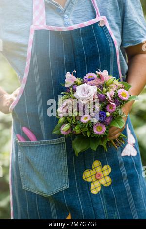 Fleuriste féminin présentant un bouquet de fleurs coloré Banque D'Images