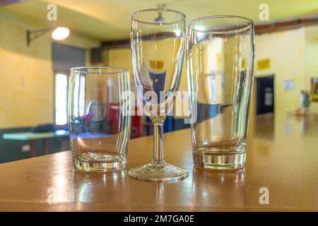 trois verres vides de différentes tailles et formes sur le comptoir d'un lieu avec un accent sur les verres Banque D'Images