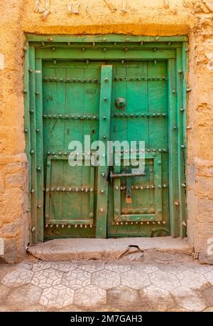 Ancienne porte verte dans la ville fantôme abandonnée d'Al Hamra, Oman Banque D'Images