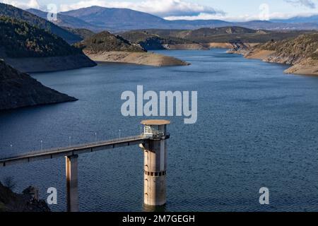 Réservoir. Proie. Barrage situé dans l'Atazar, au nord de la Communauté de Madrid. Eau damée à côté de quelques montagnes vertes et roses. Photograp horizontal Banque D'Images