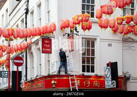 Un homme porte des lanternes en papier rouge dans les bâtiments de China Town en vue du nouvel an chinois le 9th janvier 2023 à Londres, au Royaume-Uni. Dans CH Banque D'Images