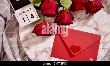 Plat de fête, composition pour la Saint-Valentin sur 14 février. fleurs de rose rouge et calendrier à la table à la maison Banque D'Images