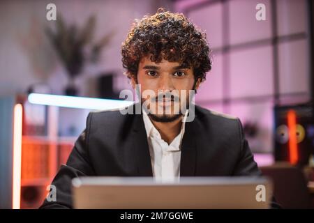Homme barbu confiant spécialiste INFORMATIQUE, économiste, courtier, expert financier en vêtements formels travaillant au bureau avec un ordinateur portable regardant la caméra. Employé de l'entreprise avec la barbe regardant l'écran de l'ordinateur. Banque D'Images