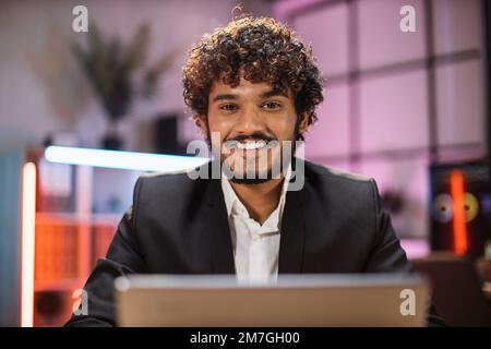 Homme barbu confiant spécialiste INFORMATIQUE, économiste, courtier, expert financier en vêtements formels travaillant au bureau avec un ordinateur portable regardant la caméra. Employé de l'entreprise avec la barbe regardant l'écran de l'ordinateur. Banque D'Images