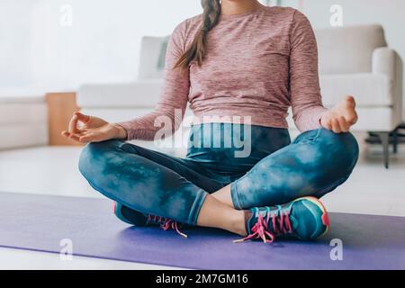 Yoga prénatal. Grossesse et méditation concept. Femme enceinte méditant pendant à la maison sur le tapis de sol en position lotus pratiquant la respiration Banque D'Images