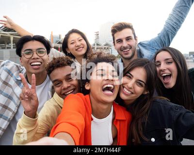 Perspective selfie d'un groupe de jeunes amis divers ayant du plaisir Banque D'Images
