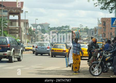 Femme portant un sac de marché sur son marchand principal dans les rues de Yaoundé au Cameroun pendant la journée Banque D'Images