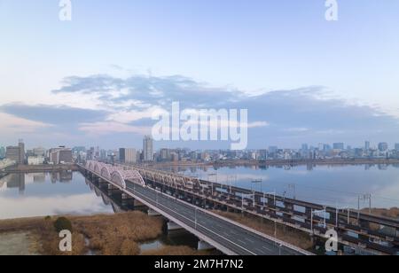 Vider les ponts de véhicule et de chemin de fer au-dessus de la rivière par la ville à l'aube Banque D'Images