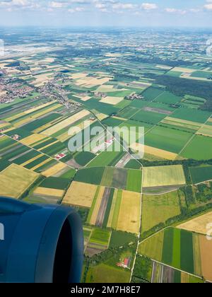 Admirez depuis le paysage ci-dessus autour de Munich, en Allemagne, comme vu par avion en juillet. La terre est luxuriante et les nuages dans le ciel donnent de la dimension aux champs et au village. Banque D'Images