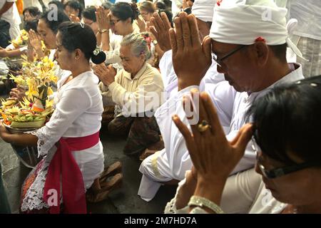 Un clan balinais prie ensemble au cours d'un rituel pour honorer et purifier les esprits de leurs membres de famille, dans un temple situé dans le complexe du temple de Besakih, sur la pente du mont Agung à Karangasem, Bali, Indonésie. Banque D'Images