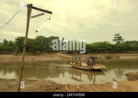 Personnes traversant la rivière par un bateau câblé alimenté par l'homme à Buni, Bekasi, West Java, Indonésie. Banque D'Images