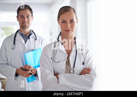 Ils prennent soin de votre santé. Portrait de deux jeunes médecins debout dans un couloir d'hôpital. Banque D'Images