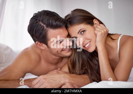 Des souvenirs qui chérissent éternellement. un jeune couple affectueux qui s'allonge au lit. Banque D'Images