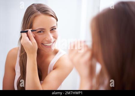 Encadrement de ses yeux magnifiques. Une jeune femme qui bruitait ses sourcils. Banque D'Images