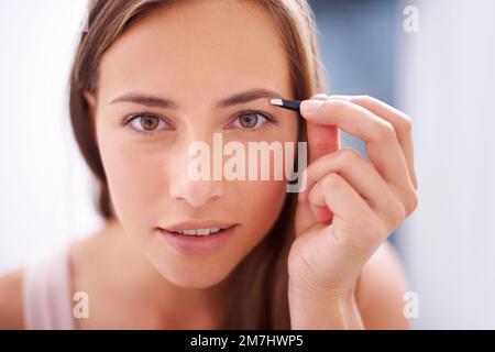 Encadrement de ses yeux magnifiques. Une jeune femme qui bruitait ses sourcils. Banque D'Images