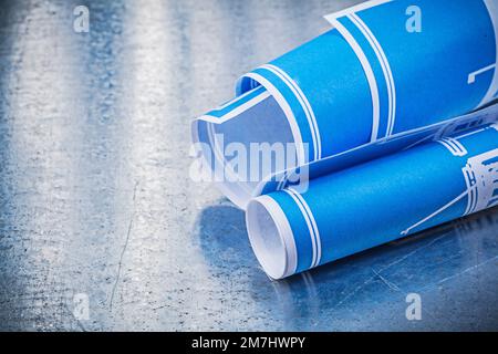 Concept de construction bleu roulé sur fond métallique rayé. Banque D'Images