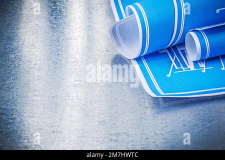 Concept de construction bleu enroulé sur fond métallique rayé. Banque D'Images