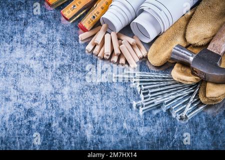 Blueprints marteau gants de sécurité construction de compteur en bois clous et tas de chevilles sur la surface métallique rayée concept d'entretien. Banque D'Images