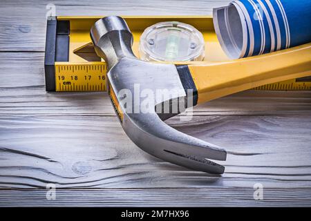 Marteau à griffe bleu laminé dessins techniques niveau de construction sur panneau en bois. Banque D'Images