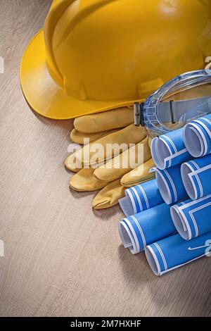 Composition du casque de construction gants de sécurité lunettes blueprints sur le concept de construction en bois. Banque D'Images