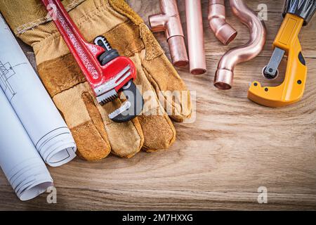 Dessins de construction gants de sécurité clé singe raccords coupe-tubes sur bois de plomberie concept. Banque D'Images