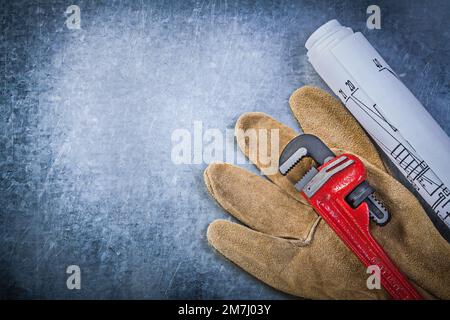 Gants de protection Monkey key key key blueprints sur fond métallique rayé concept de plomberie. Banque D'Images